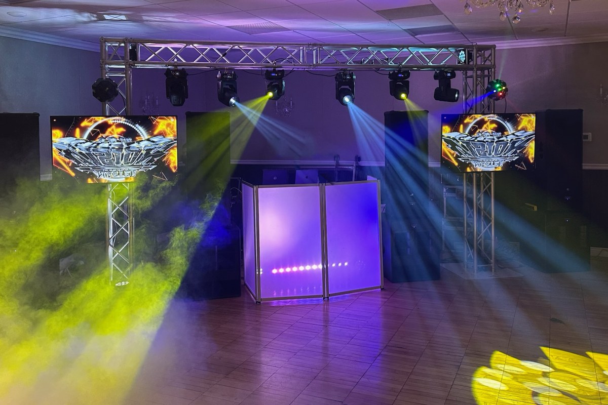Montaje Premium: arco de truss con seis luces móviles, dos pantallas en torres de truss, humo y rayos de luz sobre la pista