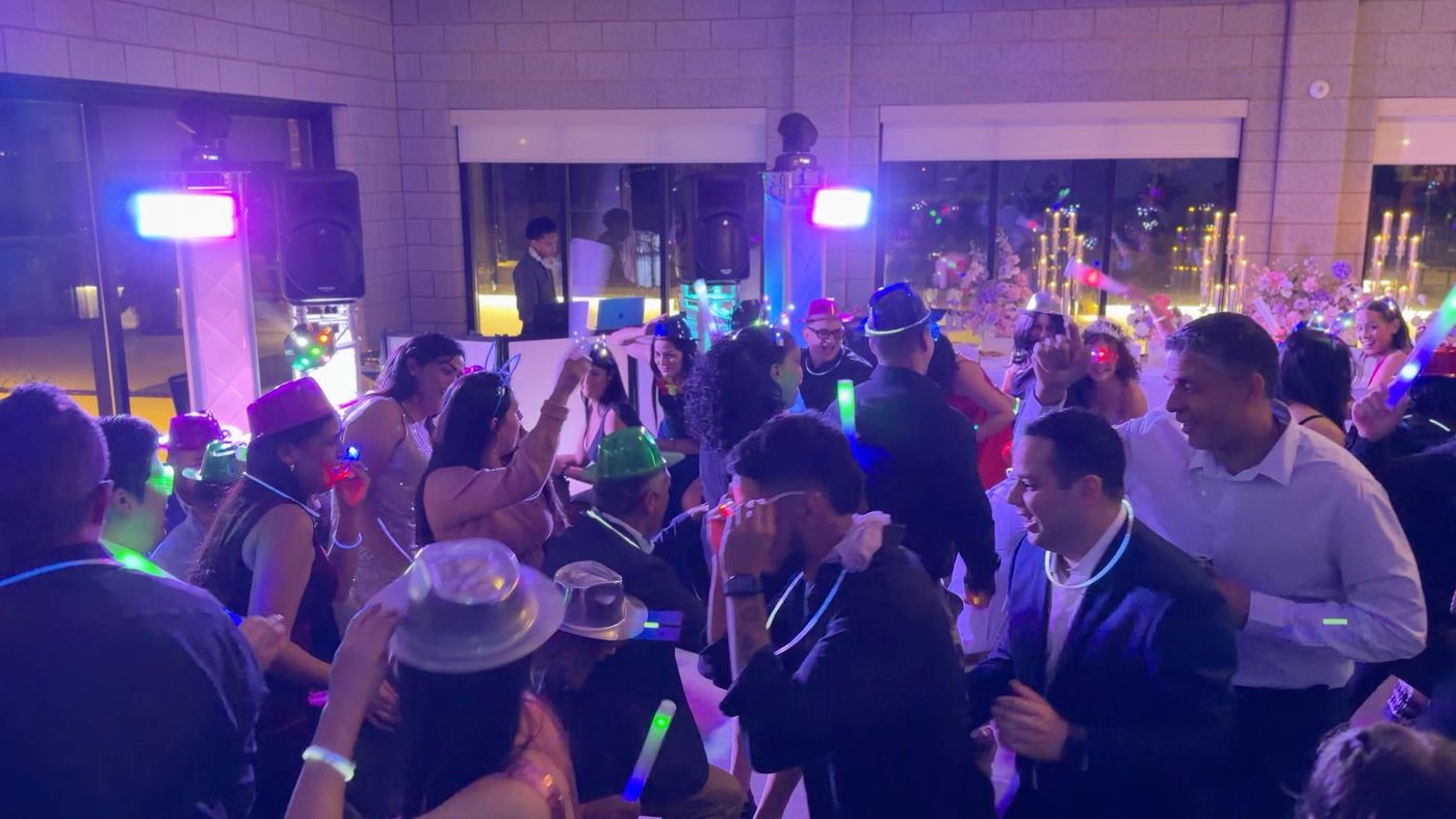 Invitados bailando con sombreros y luces led durante una quinceañera en Minnesota